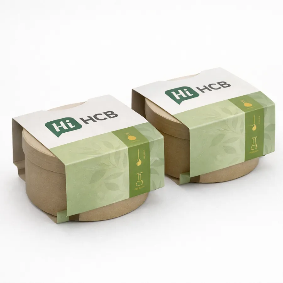 Two round cardboard tubs wrapped in eco-friendly green sleeves featuring botanical illustrations and laboratory icons- class=